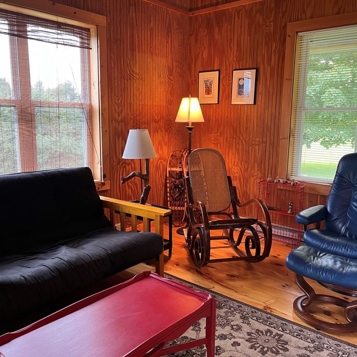 Living area with futon, rocking chair and windows